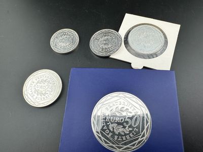 un gros plan d'une pièce d'argent posée sur une table, à côté d'autres pièces