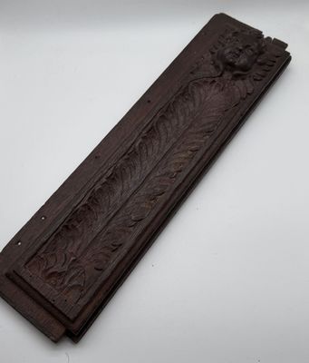 a close up of a wooden plaque on a white surface