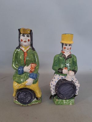 deux figurines représentant un homme et une femme assis sur des tabourets
