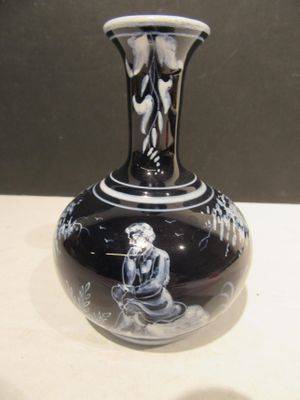 a black and white vase with a picture of a woman on it