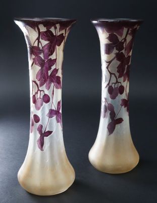 des vases violets et blancs ornés de fleurs violettes, posés sur un fond noir