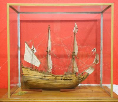 a wooden model of a ship in a glass case