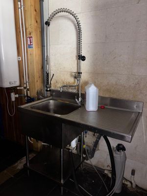 a stainless steel sink and a metal faucet in a room