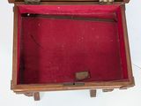 a small wooden box with a red cloth inside of it