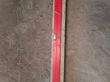 a red tape on the floor next to a ruler