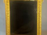 une photo représentant un miroir à cadre doré posé sur une table blanche