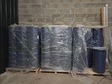 de nombreux rouleaux de plastique bleu sur une palette dans un entrepôt