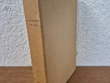 an old book sitting on top of a wooden table next to a white wall