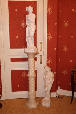 une statue placée dans un coin d'une pièce, près d'une porte