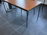 des tables et des chaises dans une pièce avec un sol carrelé et des fenêtres