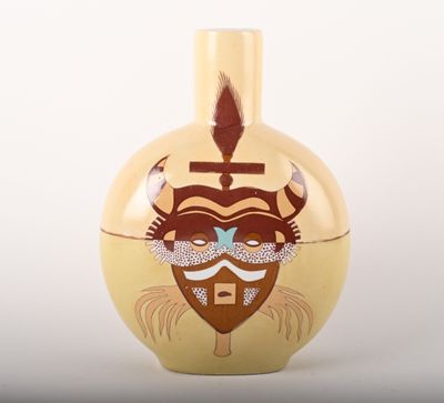 un vase jaune sur lequel est représenté le visage d'un homme