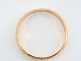 gros plan d'une bague en or sur une surface blanche