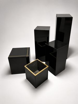 three black boxes with gold trims on a white background