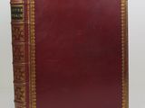 a red leather book with gold trimming and gold trimming