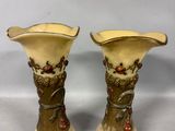 pair of antique vases with flowers and leaves on them