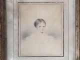 an old photo of a young girl in a white dress in a wooden frame