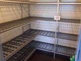 an empty refrigerator with shelves in the corner of the room