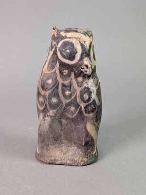 une image représentant une figurine de chouette en céramique sur fond gris