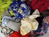 a pile of clothes that is on a bed