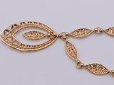 a close up of a gold necklace with an eye on it