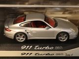a silver toy car in a display case on a table