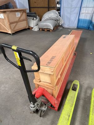 une palette sur laquelle est empilée une pile de bois, dans un entrepôt