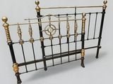 a bed with a metal frame and a clock on the headboard