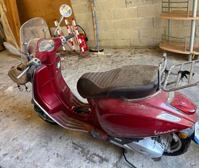 a red scooter that is parked in a garage