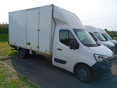 trois camions blancs garés en file indienne sur le bord de la route
