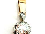 une photo d'un pendentif en diamant posé sur une surface blanche