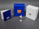 une petite figurine représentant un homme debout à côté d'une cabine téléphonique bleue