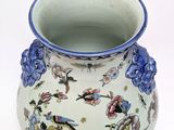 a vase with a bird on it on a white surface
