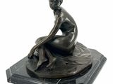 statue of a woman sitting on a marble base on a white background