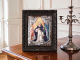 a picture of a picture of the virgin mary on a table next to a candelabra