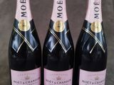 trois bouteilles de champagne Moët & Chandon sur fond gris