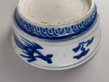 a blue and white cup with a dragon design on it