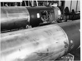 photographie en noir et blanc d'un gros tuyau métallique dans une usine