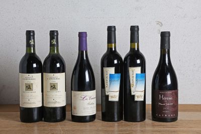 plusieurs bouteilles de vin sont alignées sur une table en bois