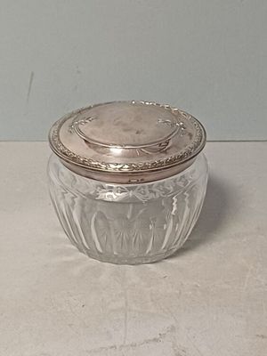 un bocal en verre muni d'un couvercle, posé sur une table