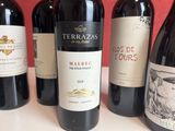 several bottles of red wine are lined up on a table