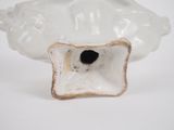 a white vase with a hole in it on a white surface
