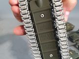 a person holding a small army tank with a chain attached to it