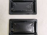 two black plastic trays on a white table