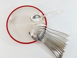 spoons and spoon rest in a red bowl on a white surface