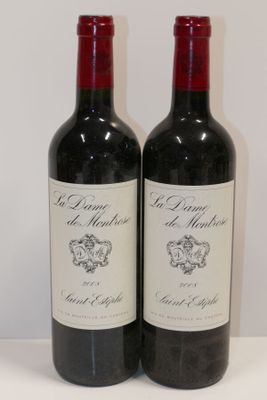 deux bouteilles de vin rouge posées sur une table blanche
