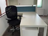a white desk with a black chair next to it