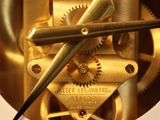 a clock that has a gold face and a black hands