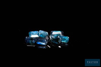 two pieces of blue and white crystals sitting on top of a black surface