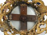 a gold cross on the top of a metal object