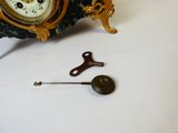 une horloge posée sur une table à côté d'une clé